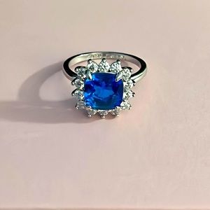 NWOT-size 8 blue sapphire and white topaz ring on a triple rhodium plated band.